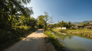 A traveler walking near a peaceful, hidden riverside cafe while riding the Samoeng Loop Chiang Mai motorbike route.