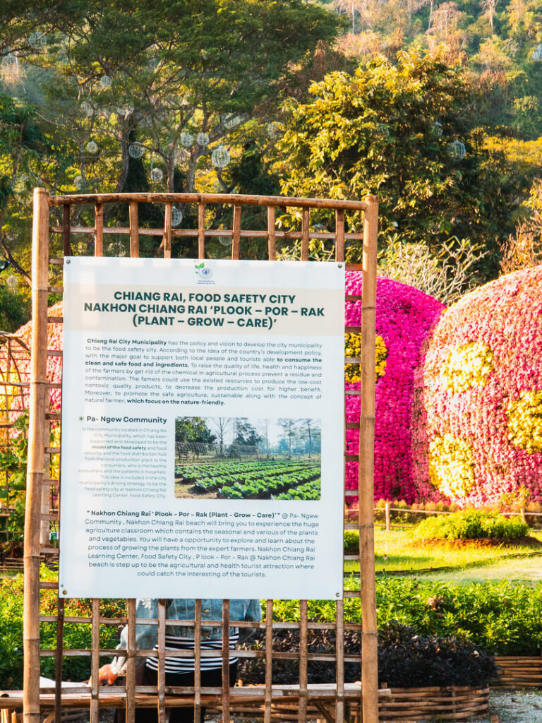 A wooden information board showing the map and rules of the riverside garden park.