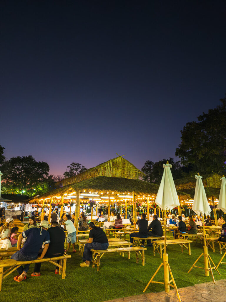 Vendors selling grilled meats and Thai snacks at the Chiang Rai River Beach food park.