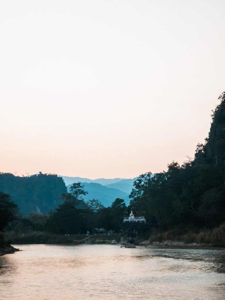 A cinematic sunset view from the sandy banks of the Kok River in Chiang Rai.