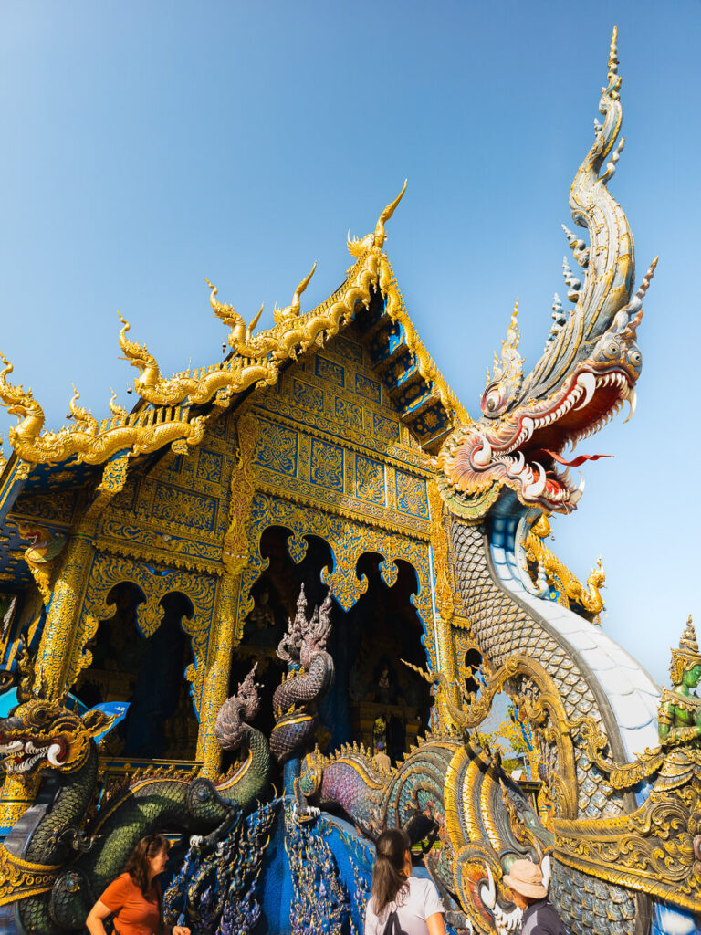 Vibrant blue and gold architectural carvings on the pillars of Wat Rong Suea Ten (Blue Temple).