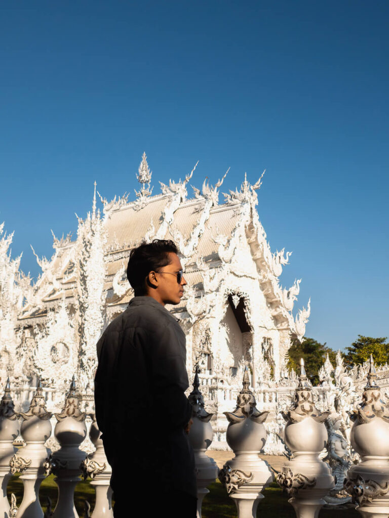 A traveler standing in front of the White Temple in Chiang Rai, Thailand