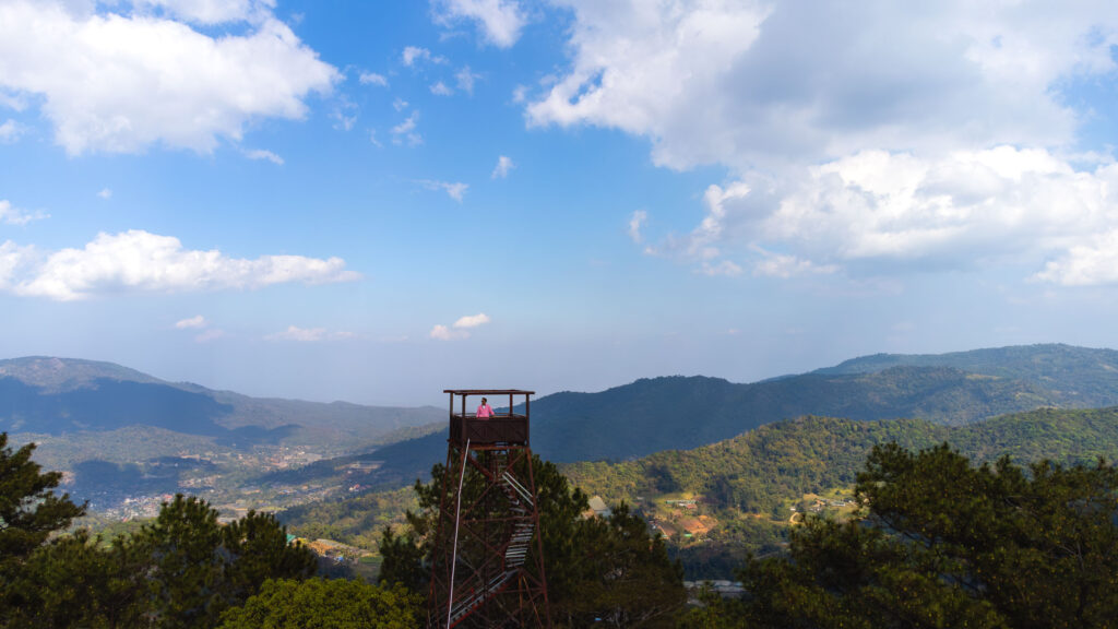 A traveler standing on a fire observation tower along the Samoeng Loop, North Thailand
