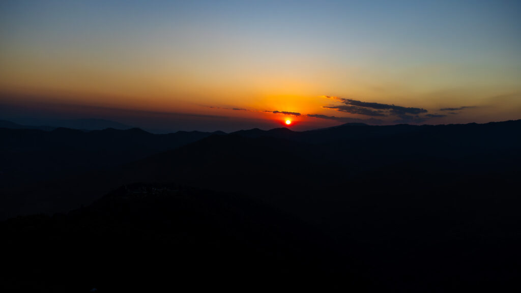 A beautiful sunset over the mountains in Mae Salong, capturing the essence of slow travel in Northern Thailand.