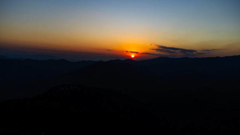 A beautiful sunset over the mountains in Mae Salong, capturing the essence of slow travel in Northern Thailand.