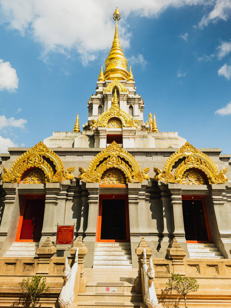 Front view of the golden Phra That Chedi Srinagarindra Stit Maha Santi Khiri temple in Mae Salong.