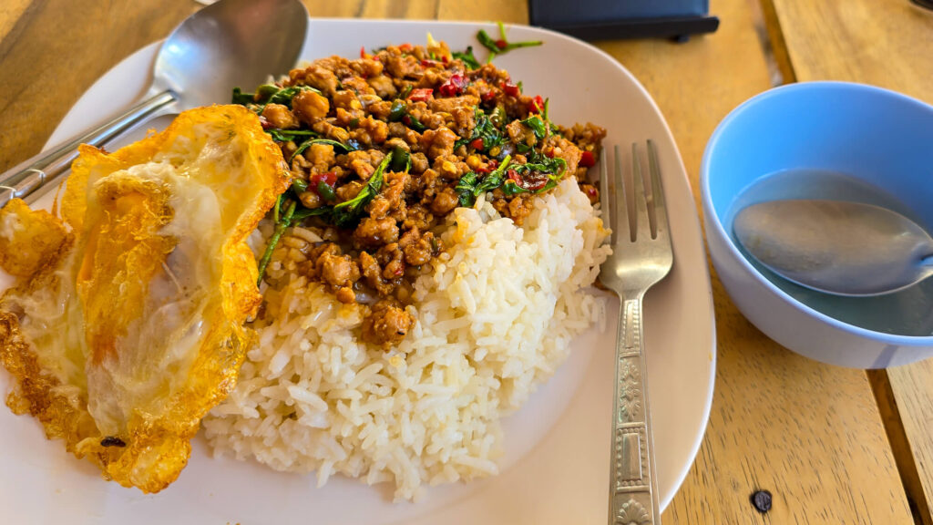 Authentic Pad Krapao and fresh watermelon at a local Chiang Mai restaurant.