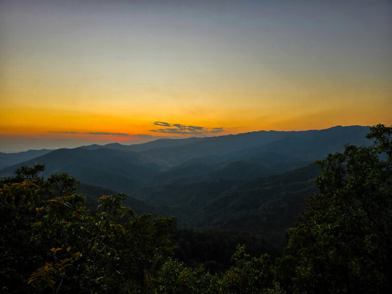 A scenic sunset view of the winding mountain roads between Chiang Mai and Chiang Rai in Northern Thailand.