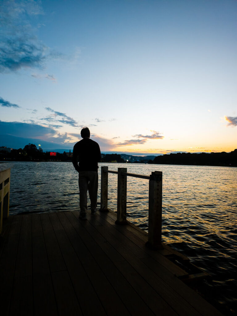 Vishal standing beside the serene Xuan Huong Lake surrounded by pine trees in the cool mountain town of Da Lat.