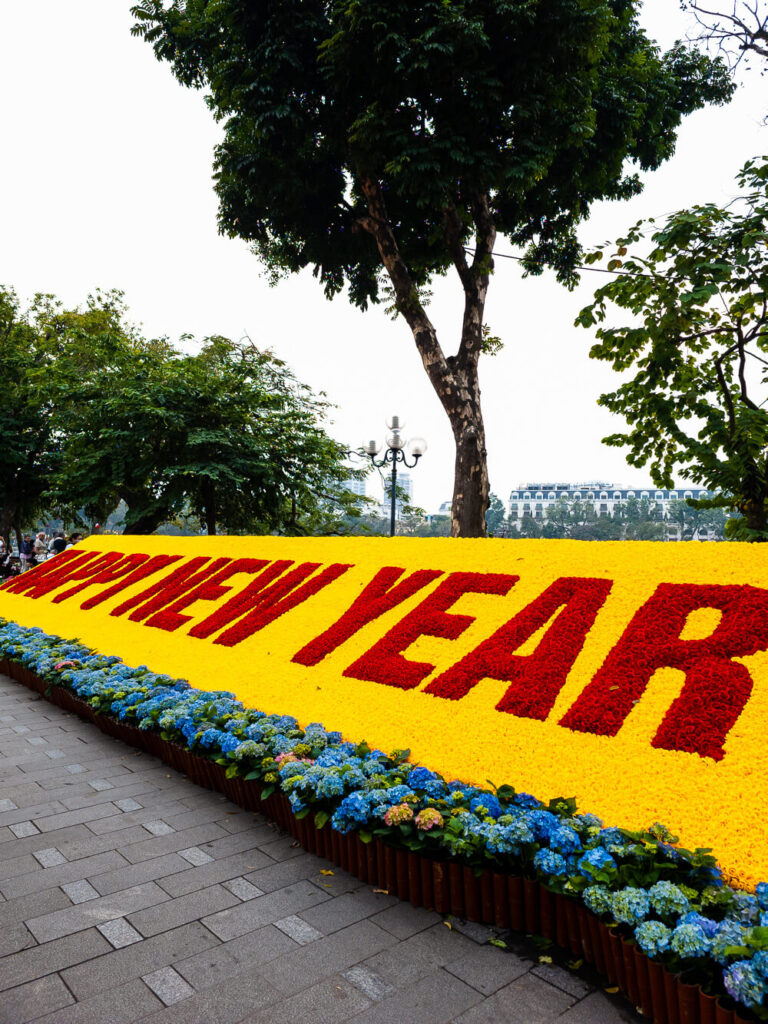 Vibrant floral arrangements and Happy New Year decorations celebrating Tet on the streets of Hanoi.