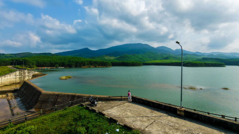A wide drone shot of a traveler overlooking the scenic dam near Hoi An during a Vietnam slow travel guide trip.