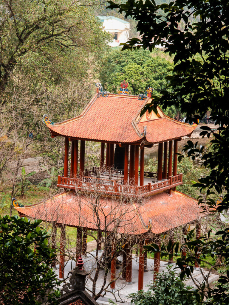 Intricate ancient temple architecture built directly into the limestone mountainside at Bich Dong Pagoda.