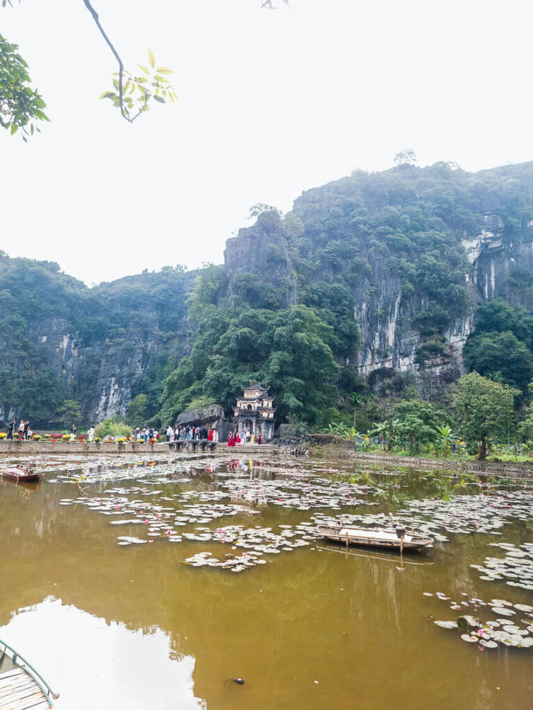 Wide shot of the iconic stone bridge and gate entrance at Bich Dong Pagoda in Ninh Binh.