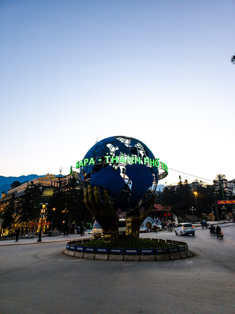 The quirky golden hand holding a globe statue located right near the Sapa Stone Church in the main town square.
