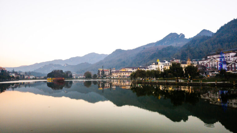Sapa travel guide: A scenic view of Sapa Lake with a beautiful mountain backdrop on a clear day.