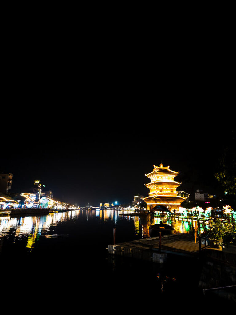 Warm lights glowing from the traditional multi-tiered architecture of Thap Tu An pagoda at night.