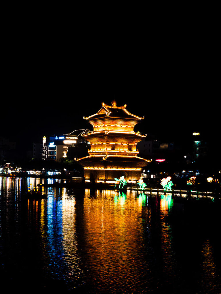 The illuminated Thap Tu An pagoda at the Bai Dinh Temple complex after dark.