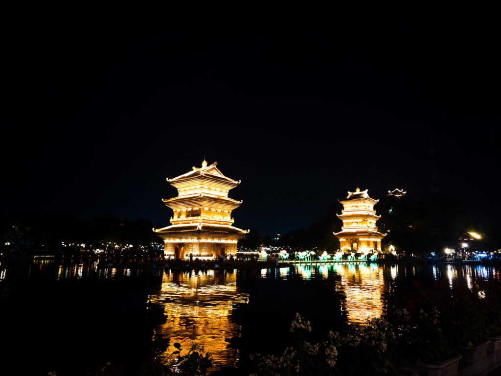The beautifully illuminated Thap Tu An tower glowing brightly at night on Ky Lan mountain in the center of Ninh Binh city.