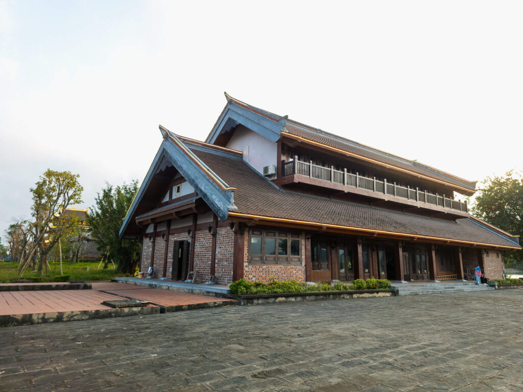 Detailed stonework and warm wooden architecture of a traditional Vietnamese temple courtyard in Ninh Binh.