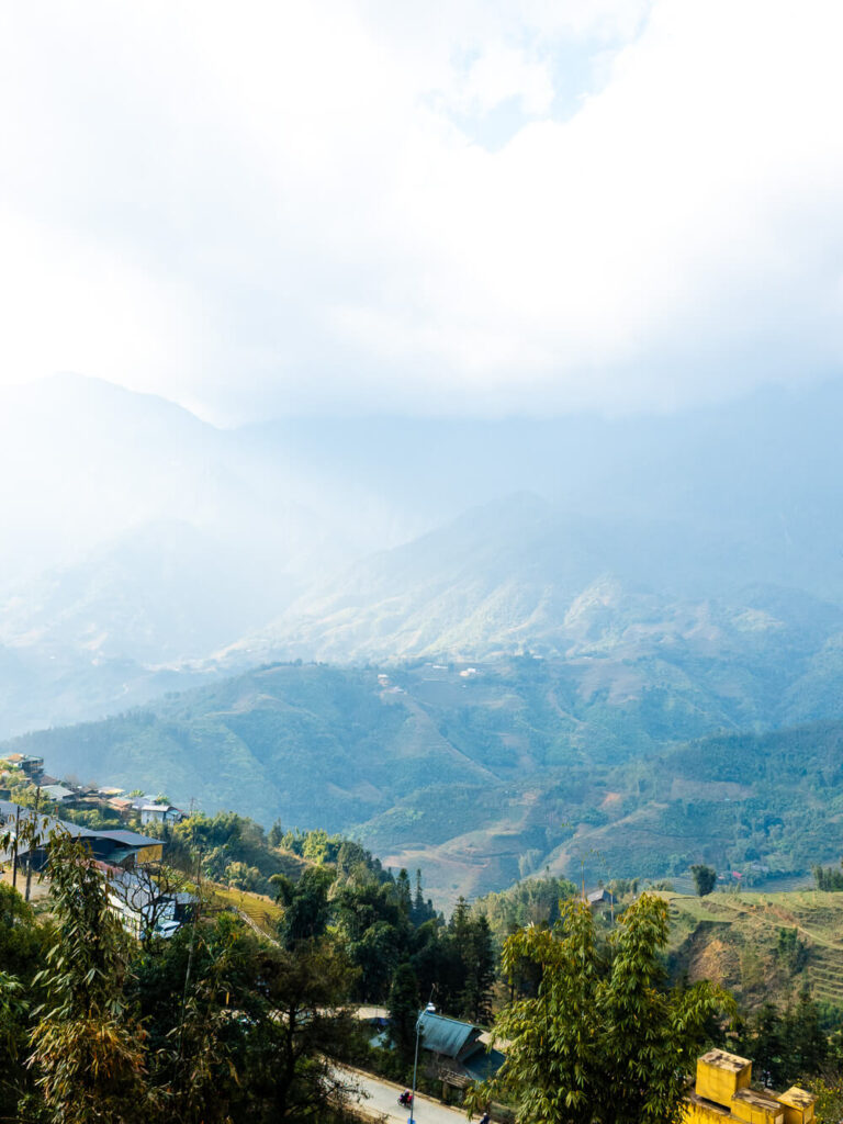 Green mountain peaks and deep valleys visible from the trail leading toward lao cai