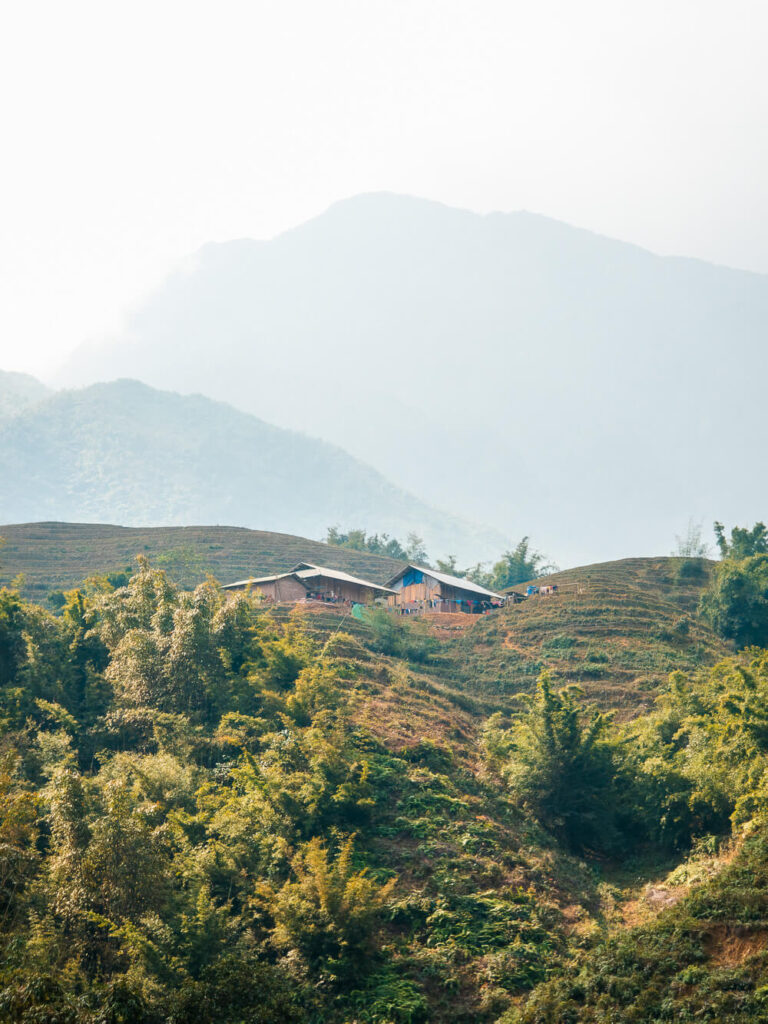 A close-up view of traditional wooden ethnic minority houses on a hillside in Sapa, Vietnam.