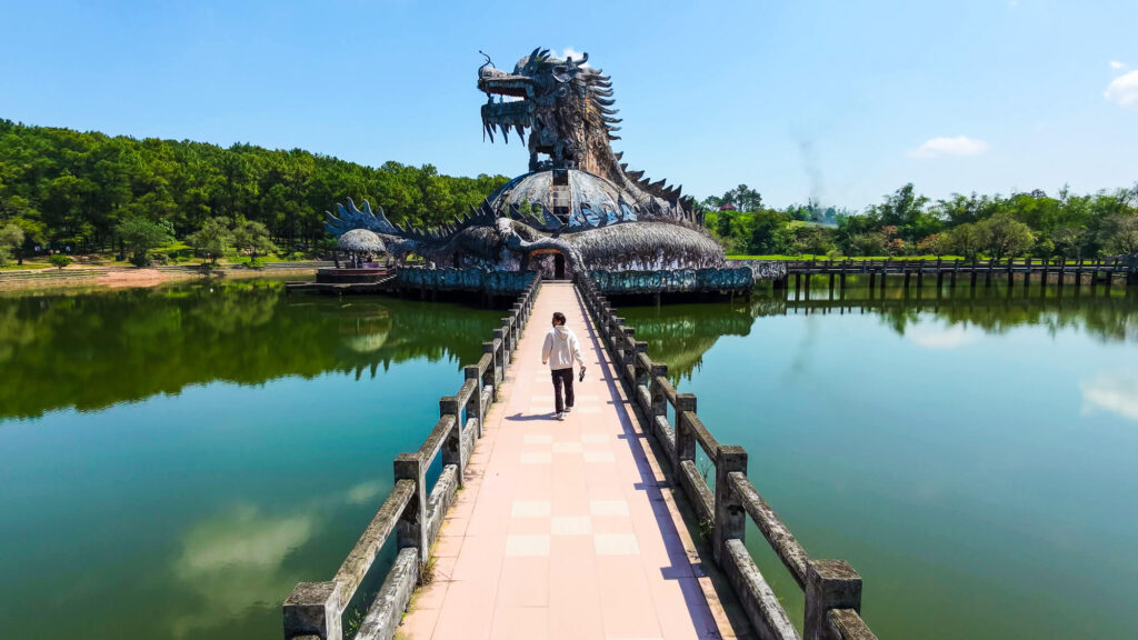 Walking along the dirt path towards the surreal abandoned dragon structure in Hue
