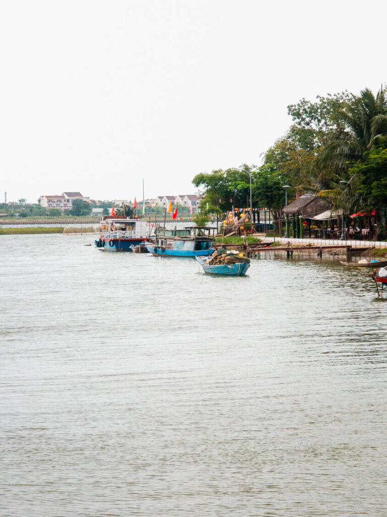 Traditional wooden fishing boats resting on the calm river waters near Cam Kim Island, just outside of Hoi An.