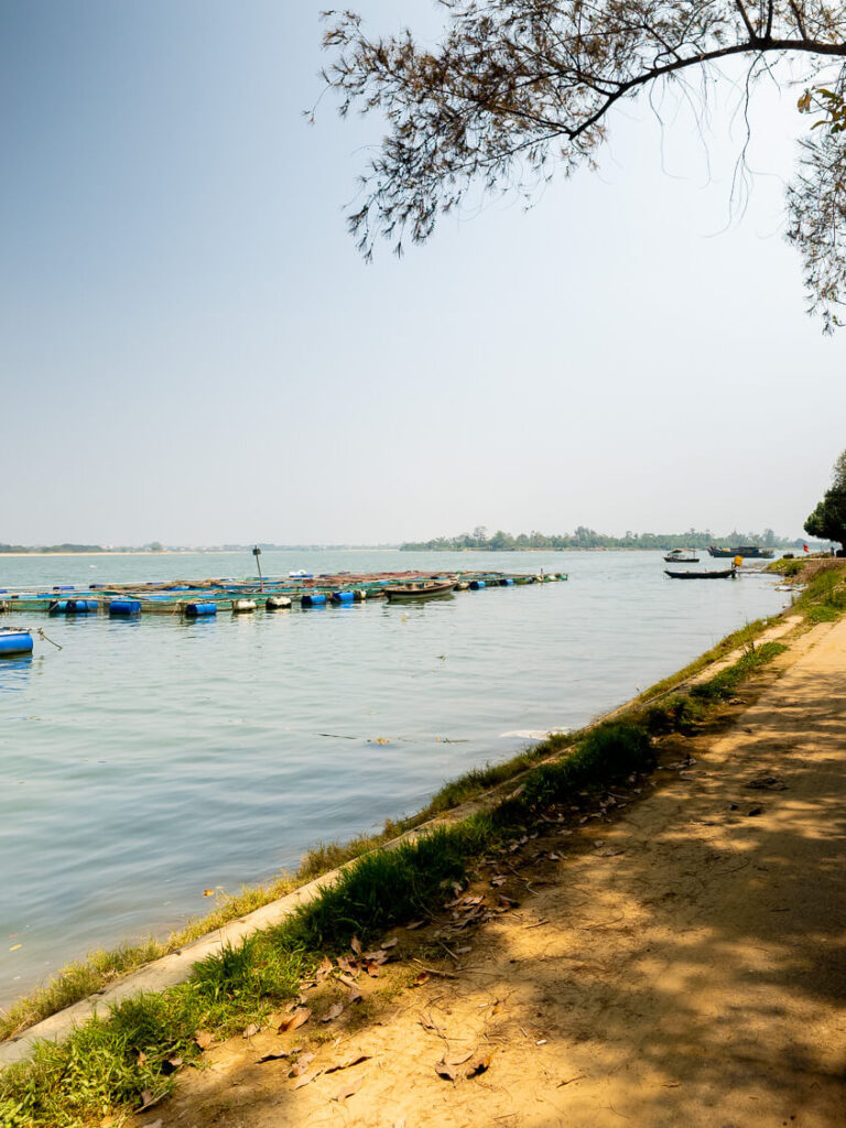 Small traditional wooden fishing boats moored along the quiet riverbanks of Cam Kim Island, just across the water from Hoi An.