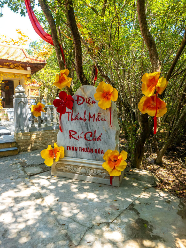 Rung Ru Cha Mangrove Forest: A Hidden Mangrove Forest Near Hue 2 A carved stone signboard resting quietly among the roots and trees near the Holy Mother shrine in the Hue wetlands.