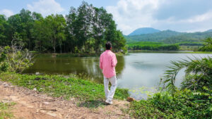 A traveler standing by a scenic lake in Vietnam, taking a quiet moment to reflect while sharing practical Vietnam travel tips for first-time visitors.