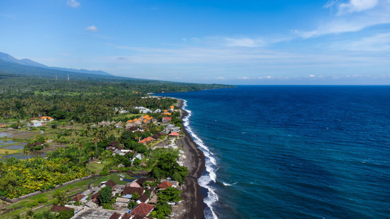 Aerial drone view of the Amed coastline and beach, setting the perfect scene for those figuring out how to plan a trip to Bali.
