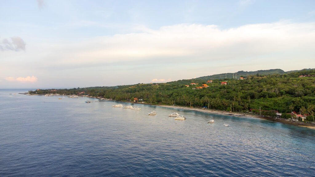 How to Plan a Trip to Bali 2026: The Ultimate Regional Travel Guide 4 Drone shot highlighting the rugged front coastline and towering limestone cliffs of Nusa Penida island meeting the blue ocean.