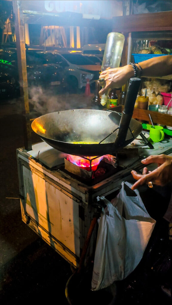 Yogyakarta Travel Budget: How Much Does Yogyakarta Cost? 3 A local street food vendor cooking fresh nasi goreng on a traditional cart in Yogyakarta