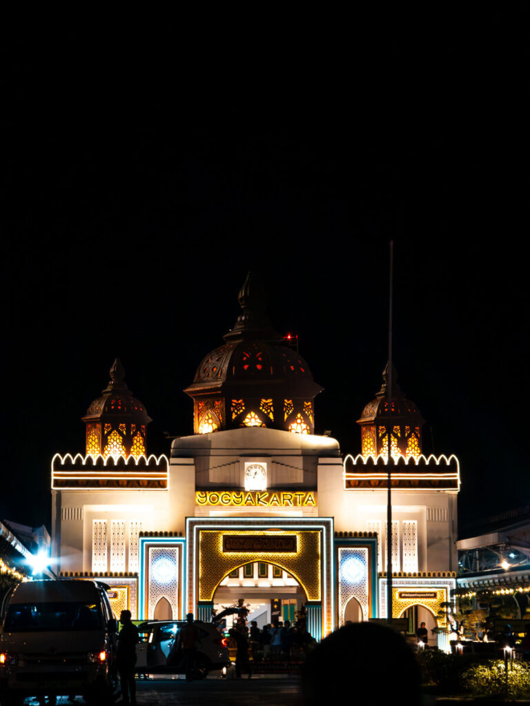 How to Travel from Yogyakarta to Surabaya 2026: The Ultimate Guide 2 The main exterior entrance of Yogyakarta Train Station, known as Tugu, with passengers arriving with their luggage.